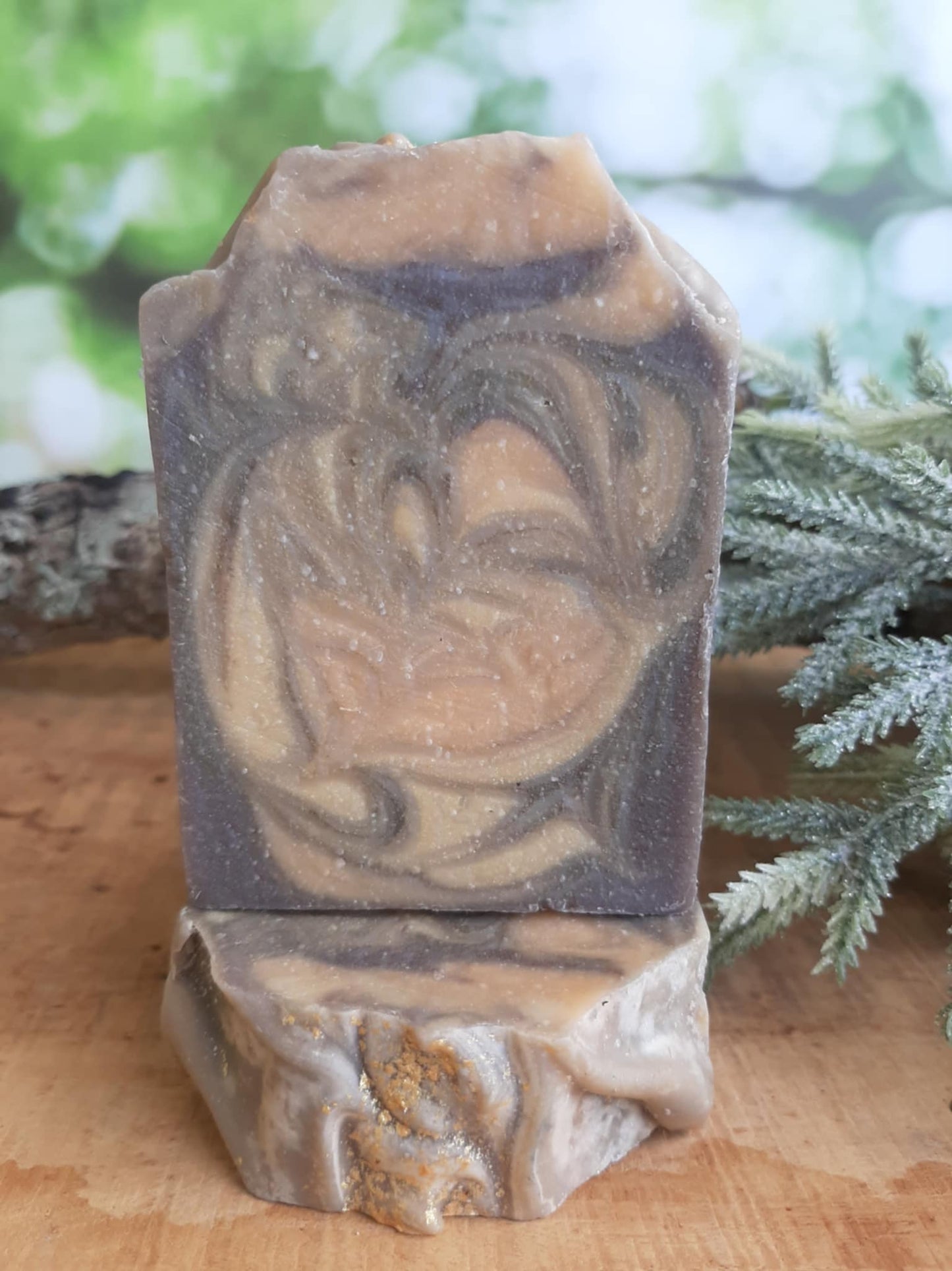 Handmade organic cedar and amber hemp body bar with hemp seeds and cedar flecks, earthy green-brown tones, on rustic wood with hemp twine