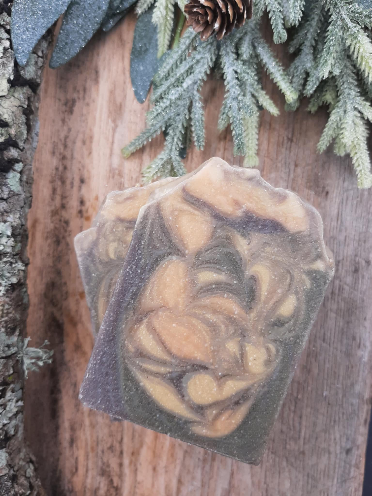 Handmade organic cedar and amber hemp body bar with hemp seeds and cedar flecks, earthy green-brown tones, on rustic wood with hemp twine