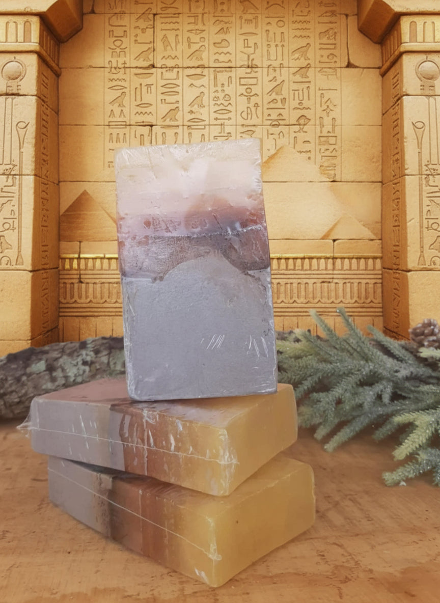 Flat lay: mango butter chunks, shea, cocoa butter, argan oil bottle, dried lime zest, gold mica