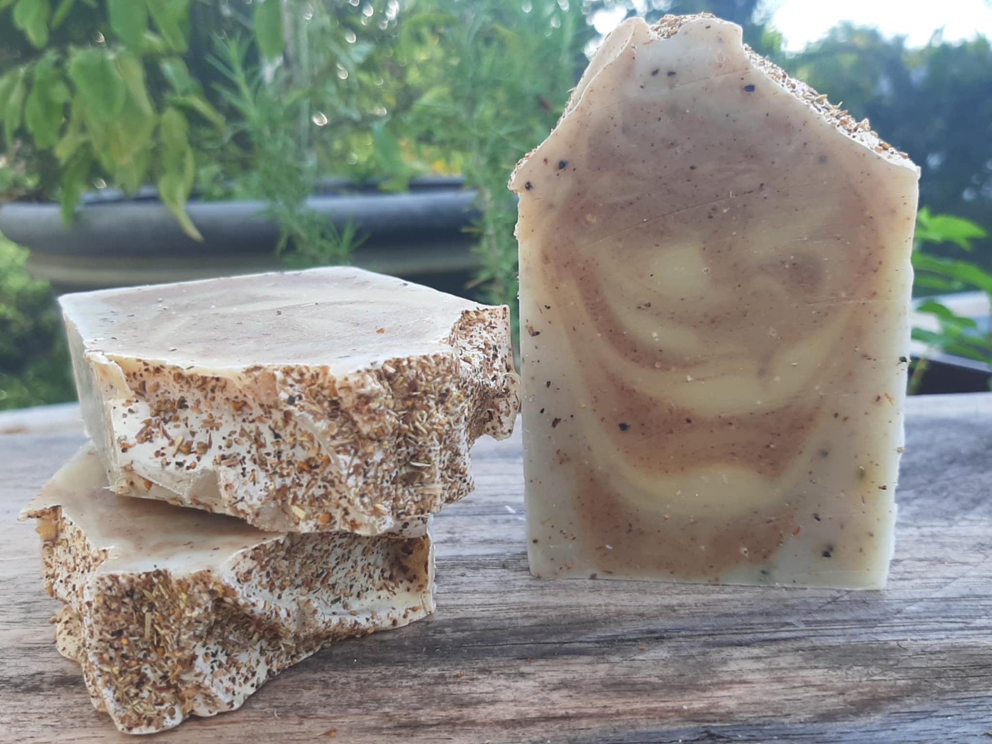 Handmade organic ginger turmeric aloe body bar with orange peel flecks and turmeric swirl, golden glow on bamboo soap dish, spa wellness vibe
