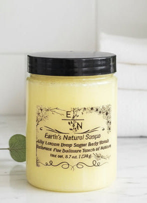 Handmade organic Lily Lemon Drop skincare gift set in kraft box with ribbon, featuring sugar scrub, bath bomb, and lotion bar, fresh lemon slices and lily petals