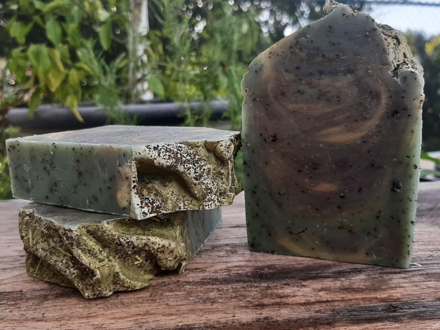 Handmade organic eucalyptus botanical body bar with embedded mint leaves and eucalyptus sprigs, textured natural soap on wooden dish, spa bathroom vibe
