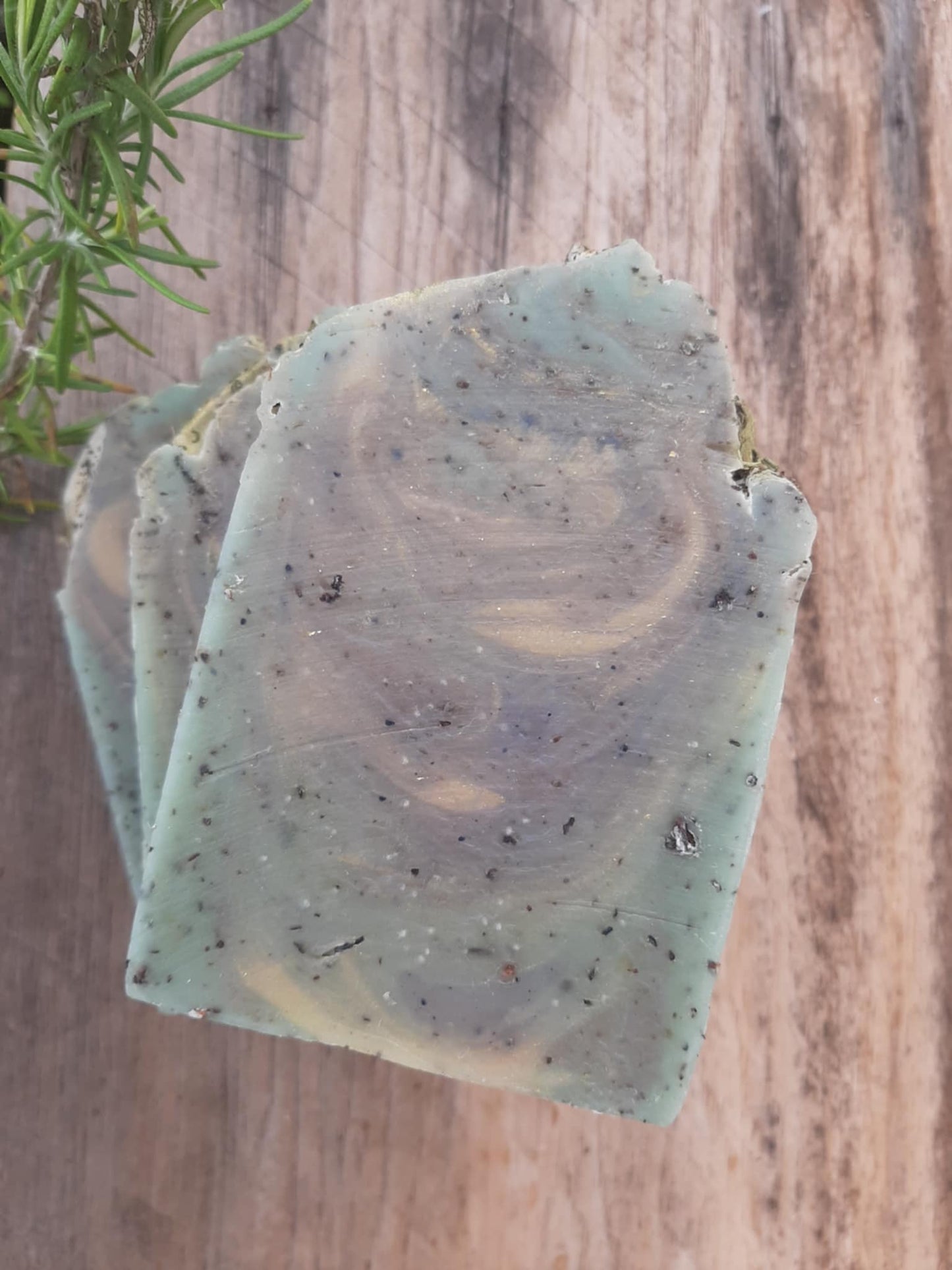 Handmade organic eucalyptus botanical body bar with embedded mint leaves and eucalyptus sprigs, textured natural soap on wooden dish, spa bathroom vibe