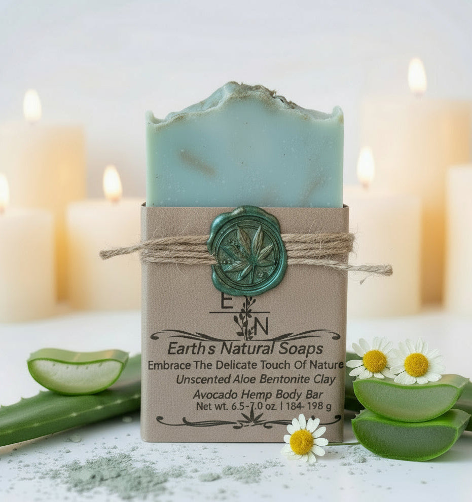 Handmade organic unscented tallow aloe avocado bentonite hemp body bar with green clay swirl and dried herbs, on white stone with fresh aloe leaf, clean spa minimalism